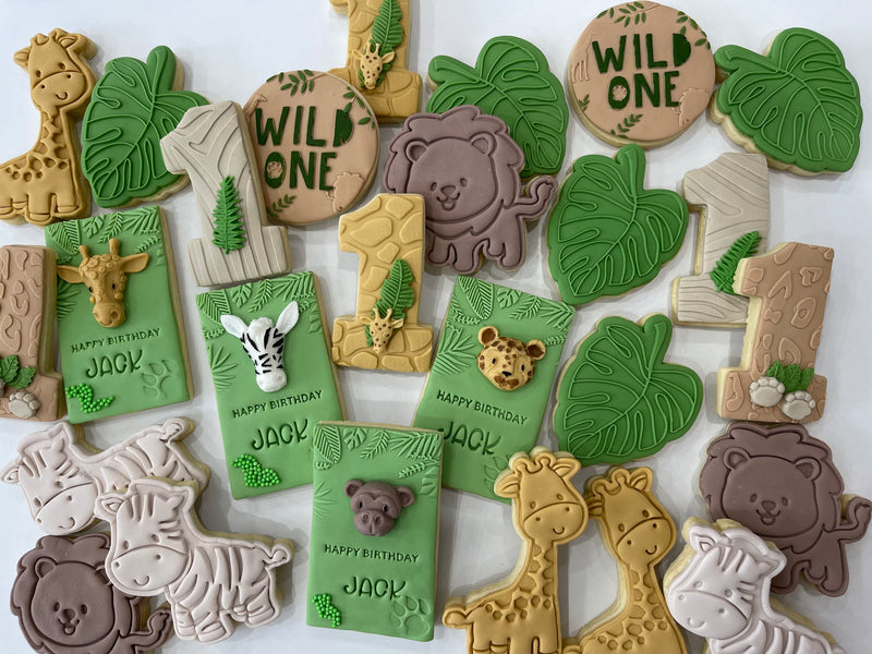 Green rectangle jungle theme cookies with yellow Giraffe and Brown Lion. Green leaf cookie and white jungle number cookie