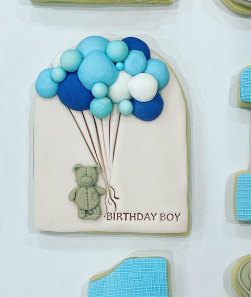 Brown Teddy Bear Cookie holding blue balloons